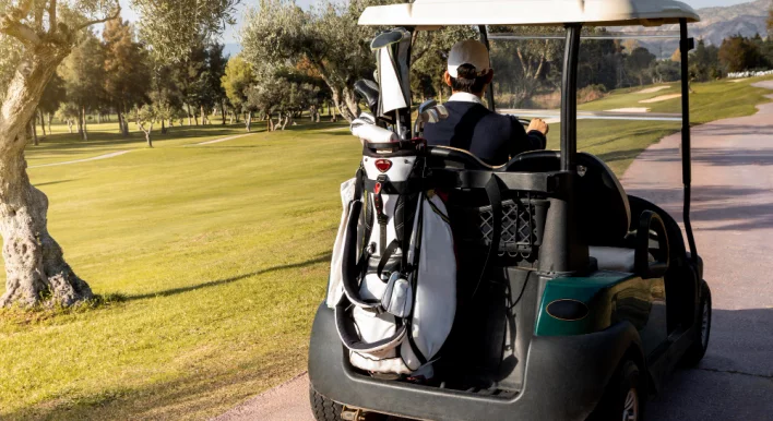 man-with-golf-cart-carrying-clubs.jpg